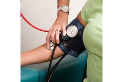 A person gets their blood pressure checked by a nurse or doctor.